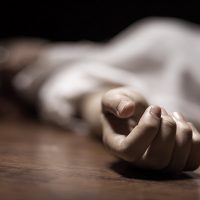 The dead woman's body. Focus on hand